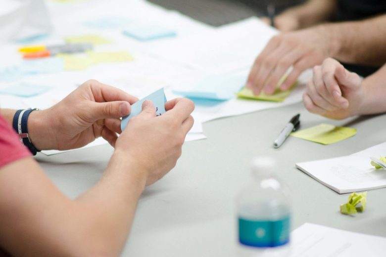 Mehrere Personen sitzen an einem Tisch mit vielen Post-Its